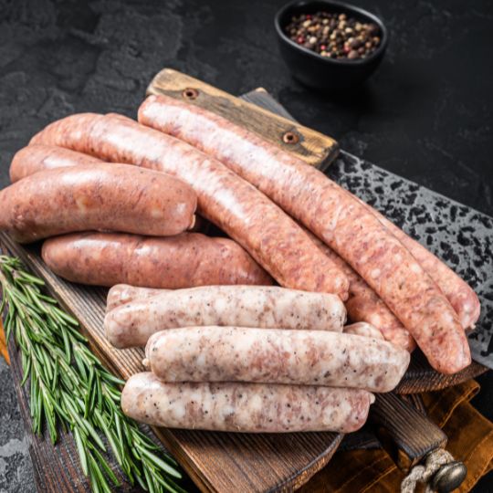 Verschiedene rohe Würste auf Holzbrett