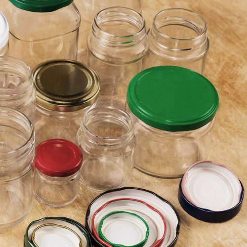 Mehrere Gläser verschiedener Größe und Form mit Bunten Schraubdeckeln.